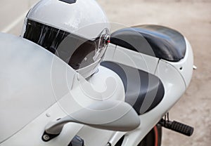 White sports motorcycle parked on the roadside.