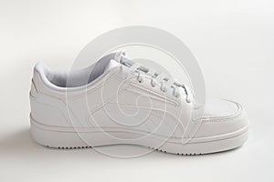 White sports shoes on a gray background close-up.