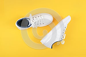White sports shoes, sneakers with shoelaces on a yellow background. Sport lifestyle concept Top view Flat lay