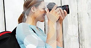 White spots floating against caucasian female photographer clicking pictures with digital camera