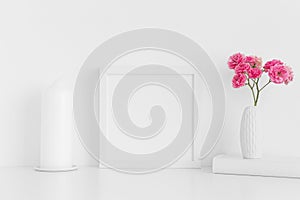 White square frame mockup with pink roses in a vase and workspace accessories on a white table