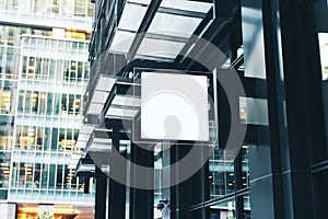 White square sign with blank space for your logo on the wall of a modern shopping mall
