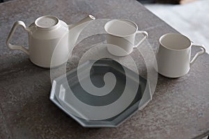 White Stacked Cups Mugs on a dark background on Gray Wood Table