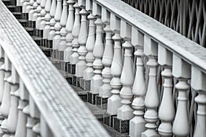 White staircase with balusters. Repetitive elements in architecture. Marble staircase in the restaurant