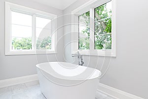 A white standalone tub in a luxury bathroom.