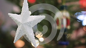 White Star on a Christmas Tree With Blurred Background. Christmas Tree With Defocused Blurred Lights Bokeh.