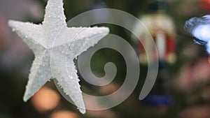 White Star on a Christmas Tree With Blurred Background. Christmas Tree With Defocused Blurred Lights Bokeh.