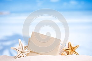 White starfish with blank retro photo on white sand beach