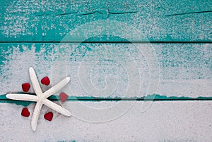 White starfish and red hearts on sandy teal blue sign