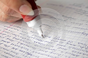 White stationery corrector correct the text in the notebook. Close up. Isolated on a white background
