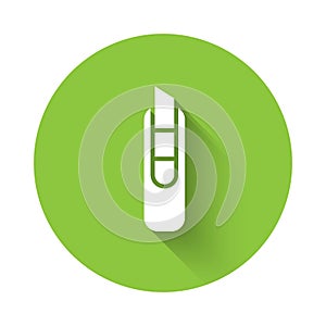 White Stationery knife icon isolated with long shadow. Office paper cutter. Green circle button. Vector Illustration