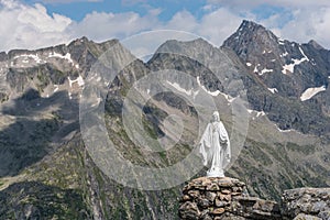 White statue of Virgin Mary, Mother of God, placed on top of the mountains.