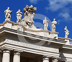 White statues on top of Vatican building, blue sky