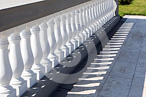 White stone balustrades along the marble tile walkway.