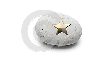 A white stone with a golden star. Space for text.