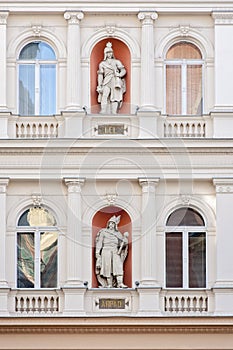 White stone or marble building with historic character or figure sculptures or statues. Arc windows, pillars and other amazing