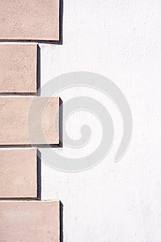 A white stone wall with pink flagstones photo