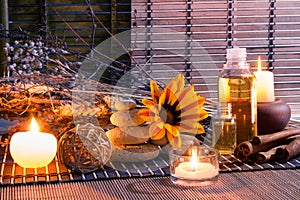 White stones, dried flowers, candles , cinnamon, oil, on mat