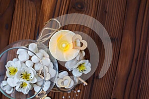 White stones in a glass vase, flowers and a big candle for spa and relaxation