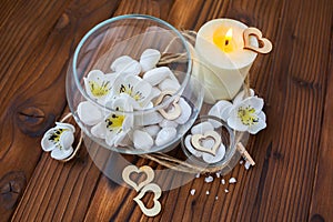 White stones in a glass vase, flowers and a big candle for spa and relaxation