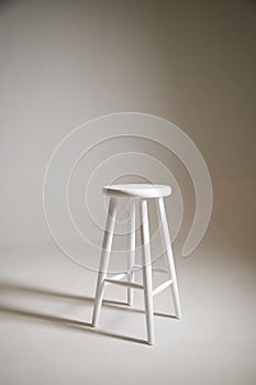 White stool with shadow on white background. Location in studio with tabouret on white background