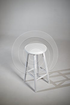 White stool with shadow on white background. Location in studio with tabouret on white background