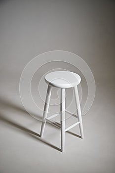 White stool with shadow on white background. Location in studio with tabouret on white background