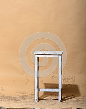 White stool in studio on light brown background