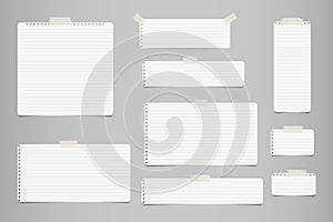 White striped note, notebook paper for message or text stuck with sticky tape on gray background.