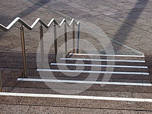 White Strips on Descending Steps With Stainless Hand Rail