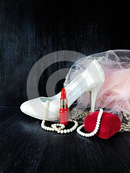 White stylish high heel shoe, pearl jewellery and red lipstick