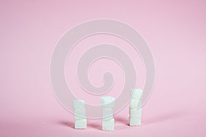 White sugar cubes on a pink background