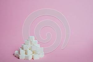 White sugar cubes on a pink background