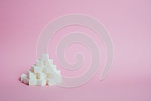 White sugar cubes on a pink background