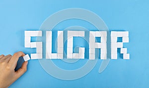 White Sugar Cubes Word SUGAR on Blue Background