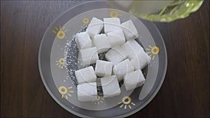 White sugar filled in a small square saucer