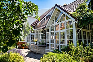 White summer house with panoramic Windows. yard and table in garden of cottage