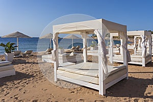 White sun canopy with mattress on luxury sand beach in tropical resort in Red Sea coast in Egypt, Africa