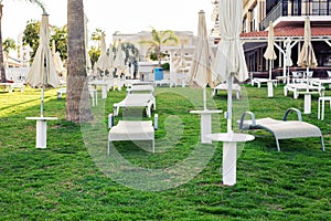 White sunbeds in Hotel`s garden. Summer holiday, hotel and spa concept