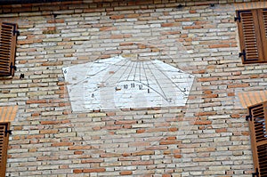 White sundial on a house wall photo