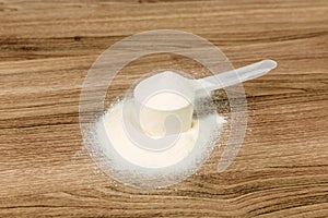 White supplement  scoop on a wood patterned background