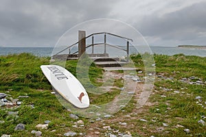 White surf board with sign rescue ashore by the ocean. Nobody. Health and safety measures. Cloudy sky. Dangerous sport concept