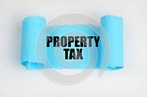 On a white surface, a blue scroll of paper with the inscription - PROPERTY TAX