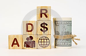 On a white surface, dollars and cubes with images and the inscription - ADR