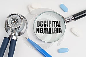 On a white surface lie pills, a pen, a stethoscope and a magnifying glass with the inscription - Occipital Neuralgia
