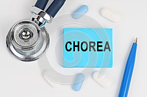 On a white surface lie pills, a stethoscope and stickers with the inscription - chorea