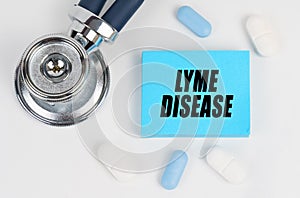 On a white surface lie pills, a stethoscope and stickers with the inscription - lyme disease