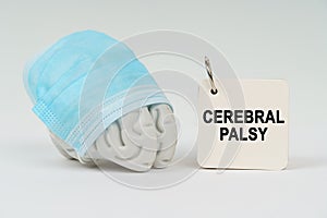 On a white surface next to the brain there is a notepad with the inscription - CEREBRAL PALSY