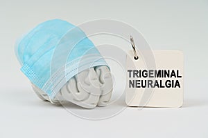 On a white surface next to the brain there is a notepad with the inscription - Trigeminal neuralgia