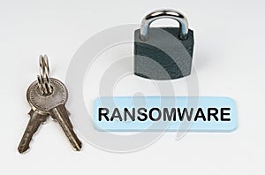 On a white surface there is a lock, keys and a blue sign with the inscription - Ransomware